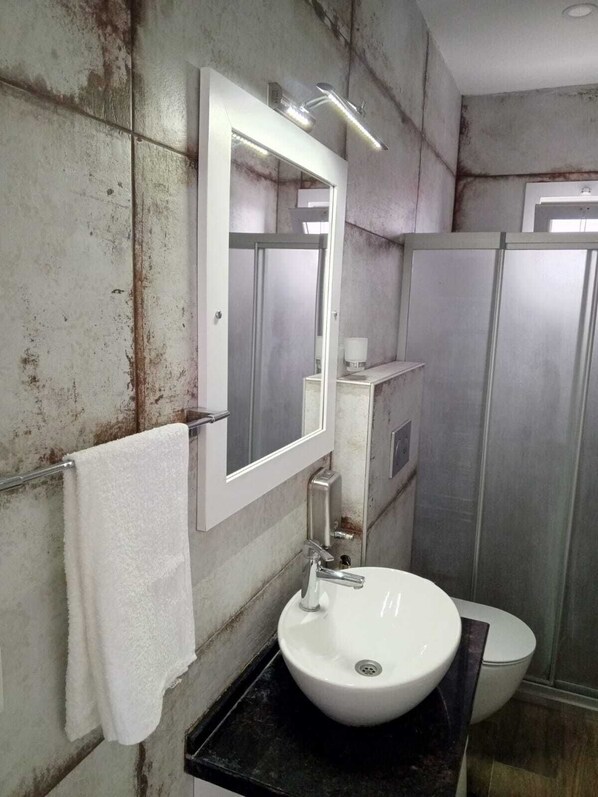 A bathroom with a white sink, a mirror, and a towel hanging on a rack. - Port Hotel Tasucu (Silifke)