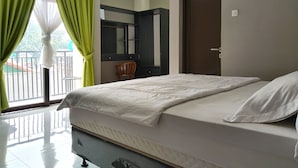 Een slaapkamer met een bed, een stoel, een kledingkast en een deur.