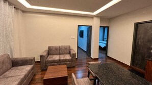 A modern living room with a sofa set, a coffee table, and a dining table. - The Getaway BNB (Shimla)
