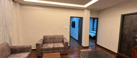 A modern living room with a sofa set, a coffee table, and a dining table.