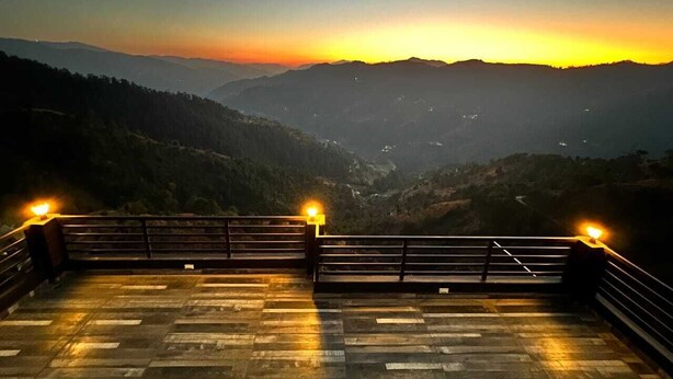 A sunset view from a bridge with railings and a paved walkway. - The Getaway BNB (Shimla)
