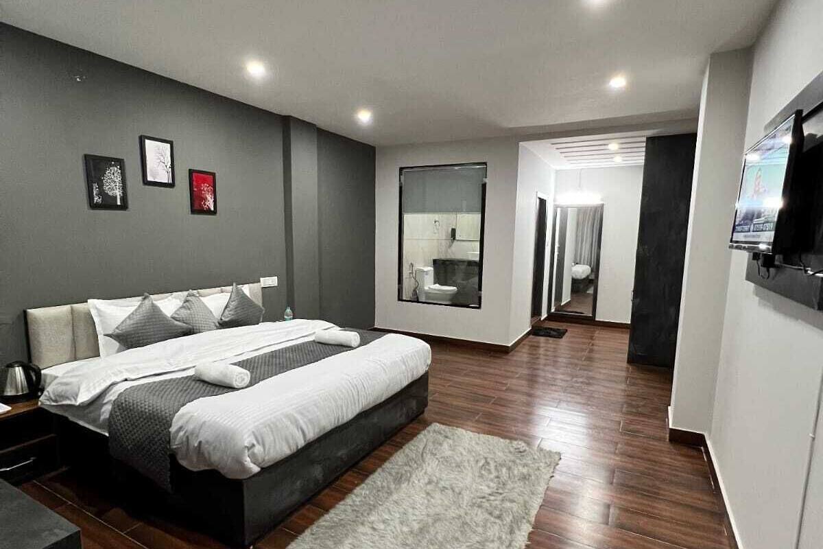 Un dormitorio moderno con una cama grande, un escritorio y un televisor.