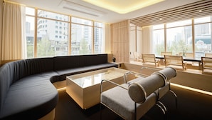 Un salon moderne comprenant un canapé, une table basse et un coin repas avec des chaises et une table.