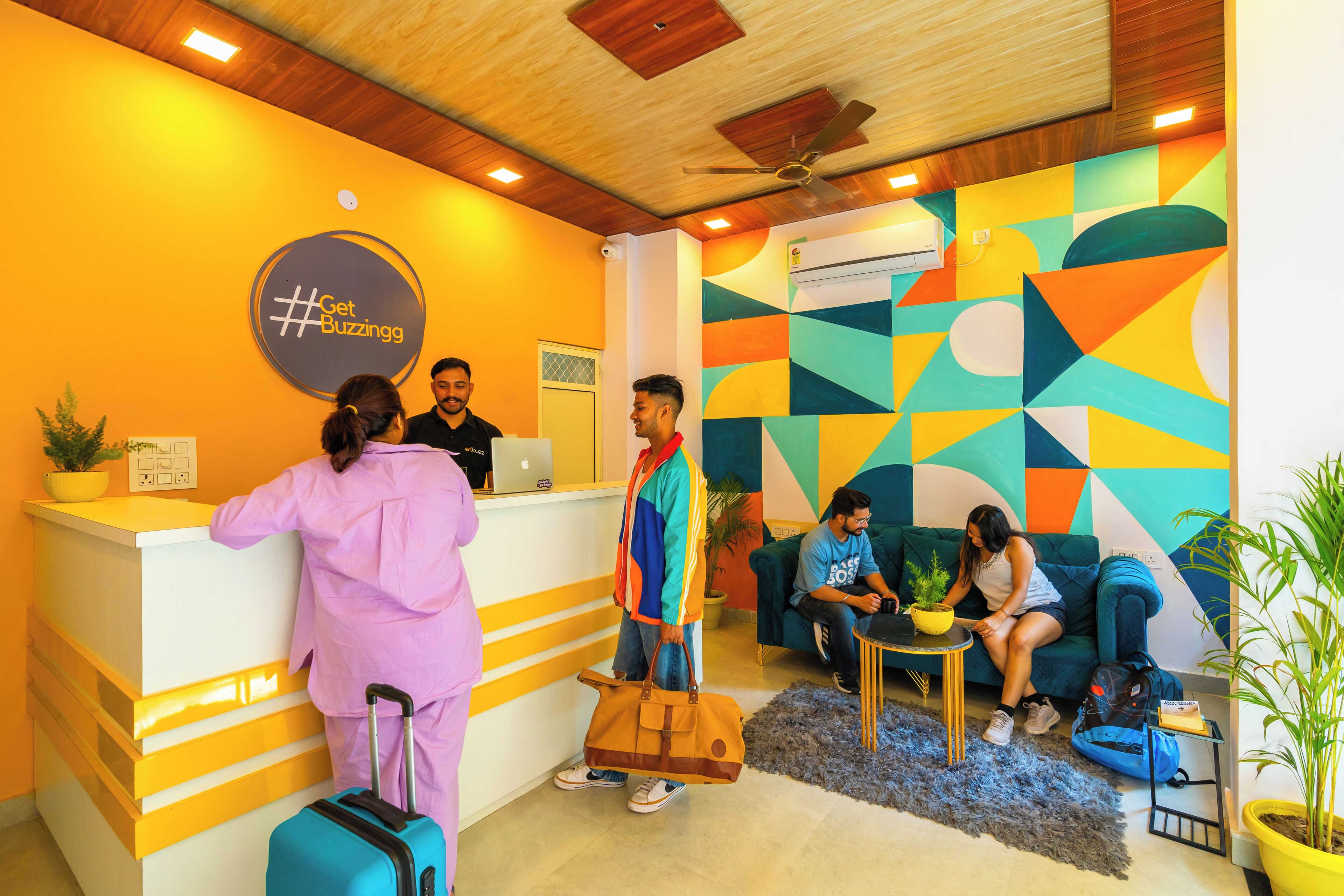 A reception area with a colorful geometric wall design, a reception desk, and seating for guests.