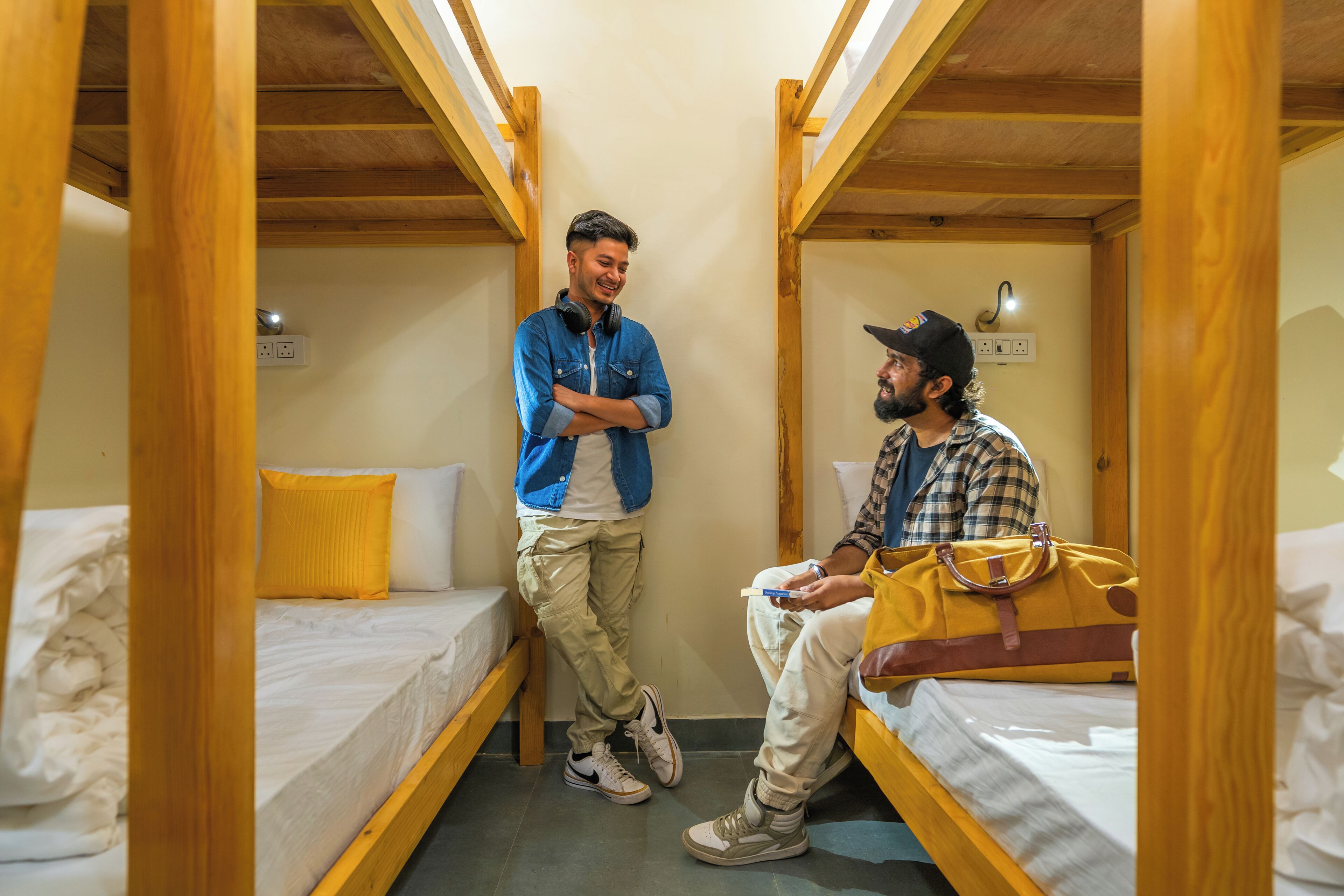 A dormitory room with bunk beds, wooden beams, and a simple layout.