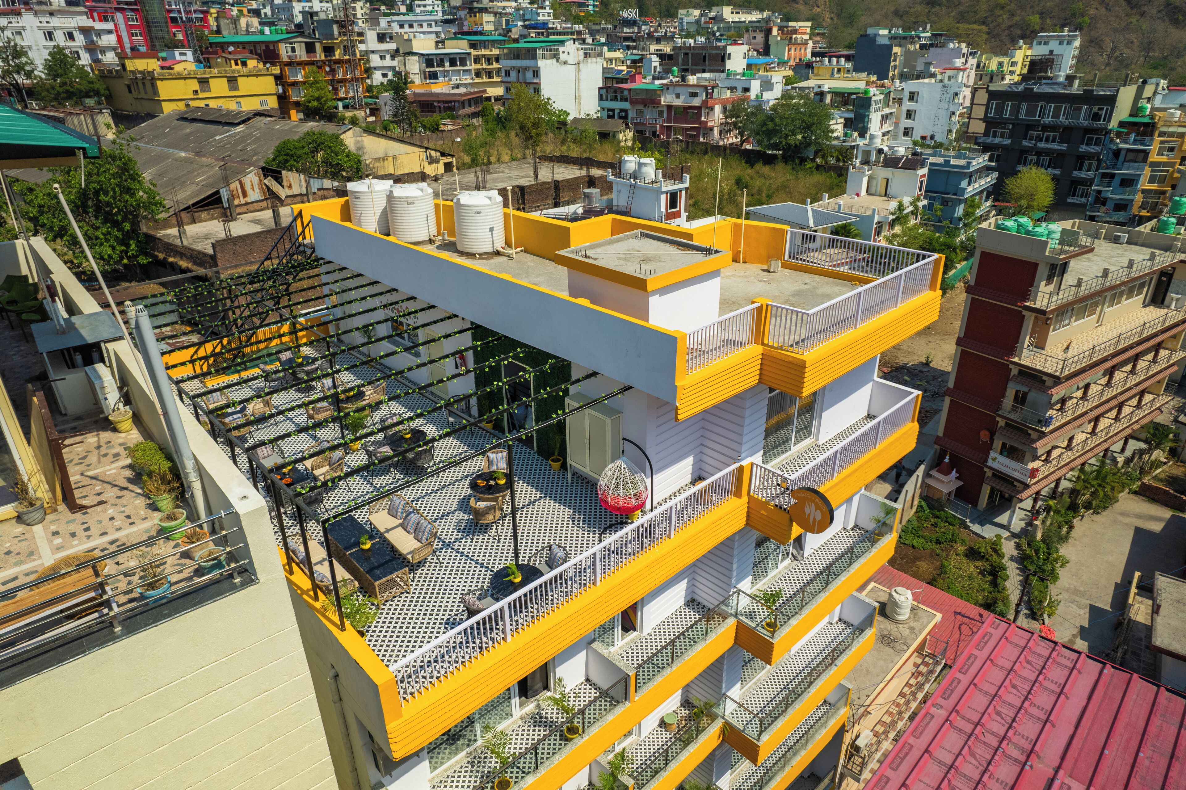 A multi-story building with balconies, some with railings and others open.