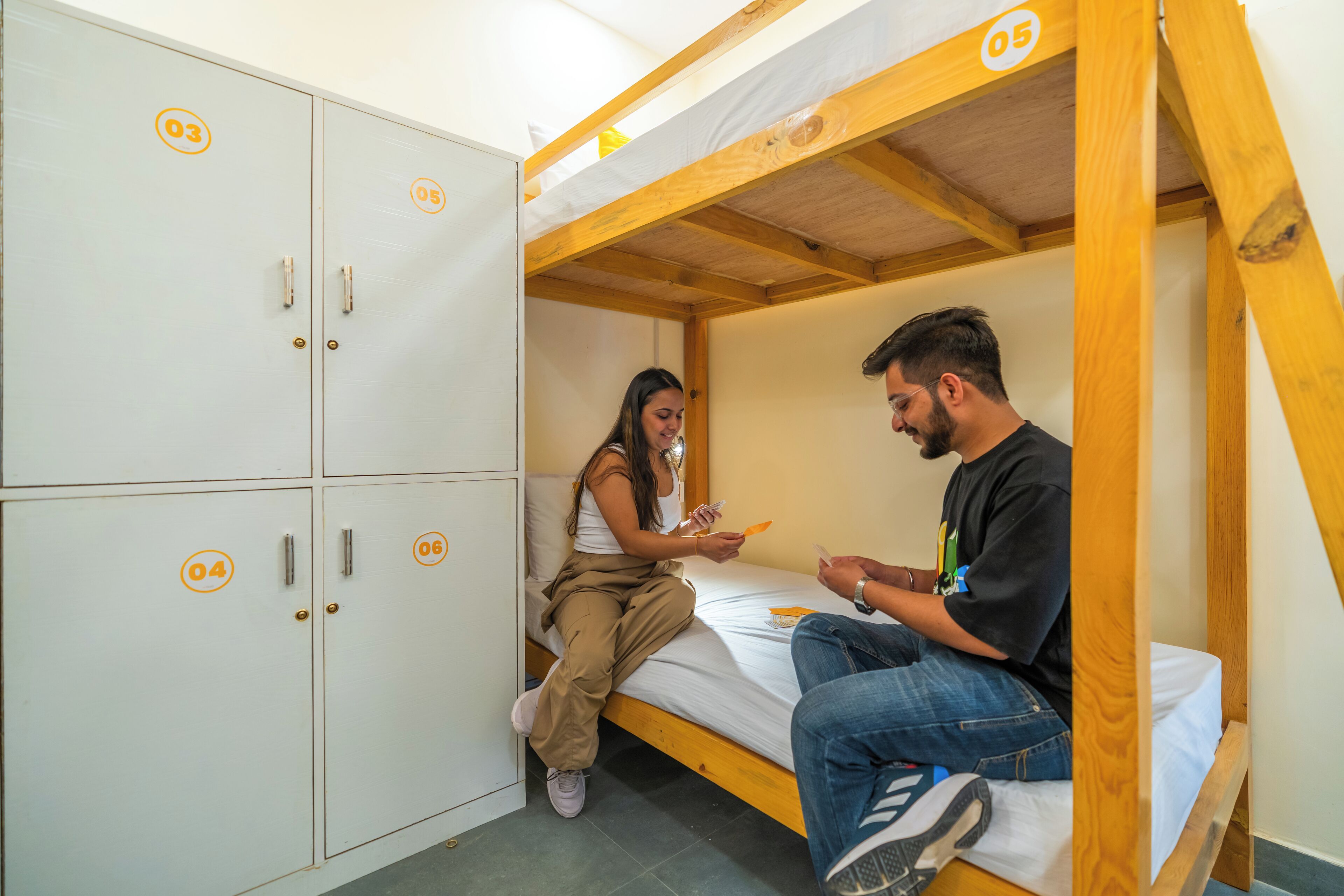 Une chambre avec des lits superposés, un plafond en bois et des casiers blancs.