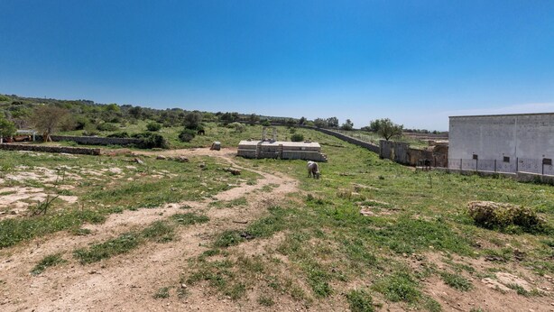 An outdoor area with a dirt path, a stone wall, and a building with a flat roof. - 3787 ADT - Camera Matrimoniale Luxury (Mottola)
