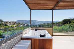 A modern outdoor hot tub area with a view of a residential area and hills. - Ruins Luxury Resort (Bodrum)