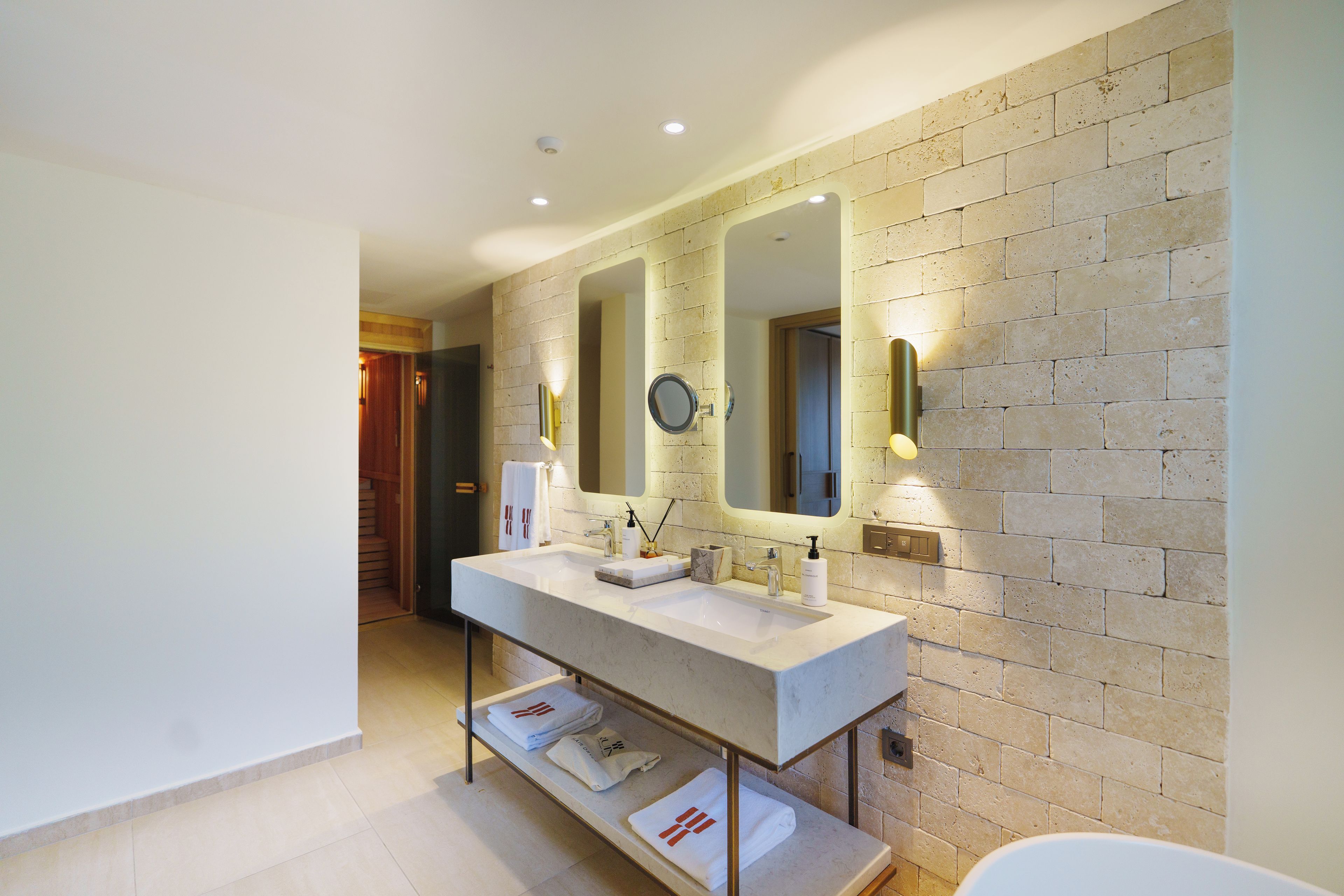 Une salle de bain moderne avec un double lavabo, un grand miroir et une baignoire.