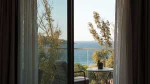A balcony with a view of the sea, a chair, and a table with a potted plant. - Ruins Luxury Resort (Bodrum)