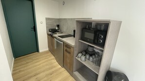 A compact kitchen with a microwave, stove, and sink.