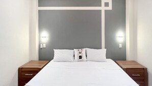 A bedroom with a bed, two bedside tables, and a wall-mounted light fixture. - Best Location + Clean, Safe, Just Built (Sayulita)