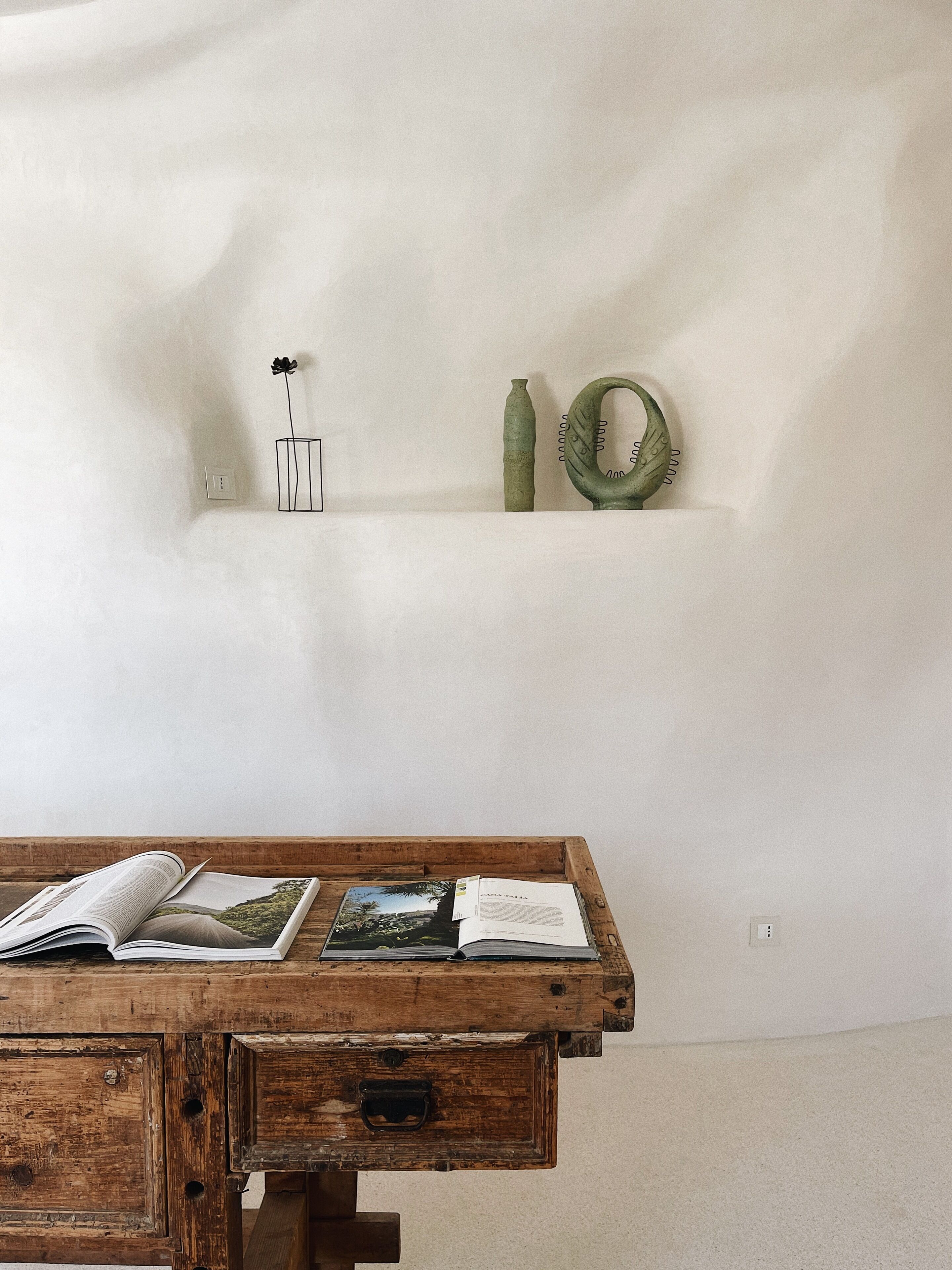 Una mesa de madera con libros abiertos y un banco de madera.