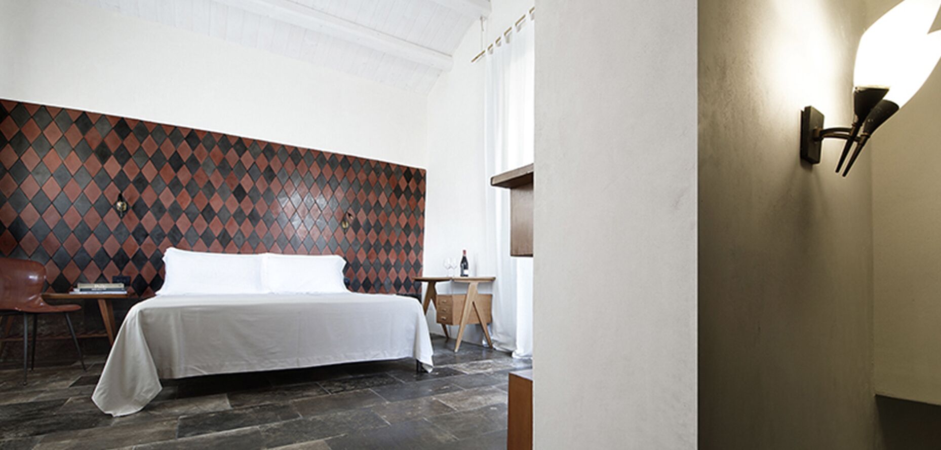 Una habitación de hotel con una cama, un escritorio y una silla.