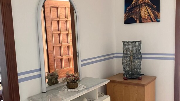 Un meuble-lavabo de salle de bain avec un miroir, un vase et une image de la Tour Eiffel.