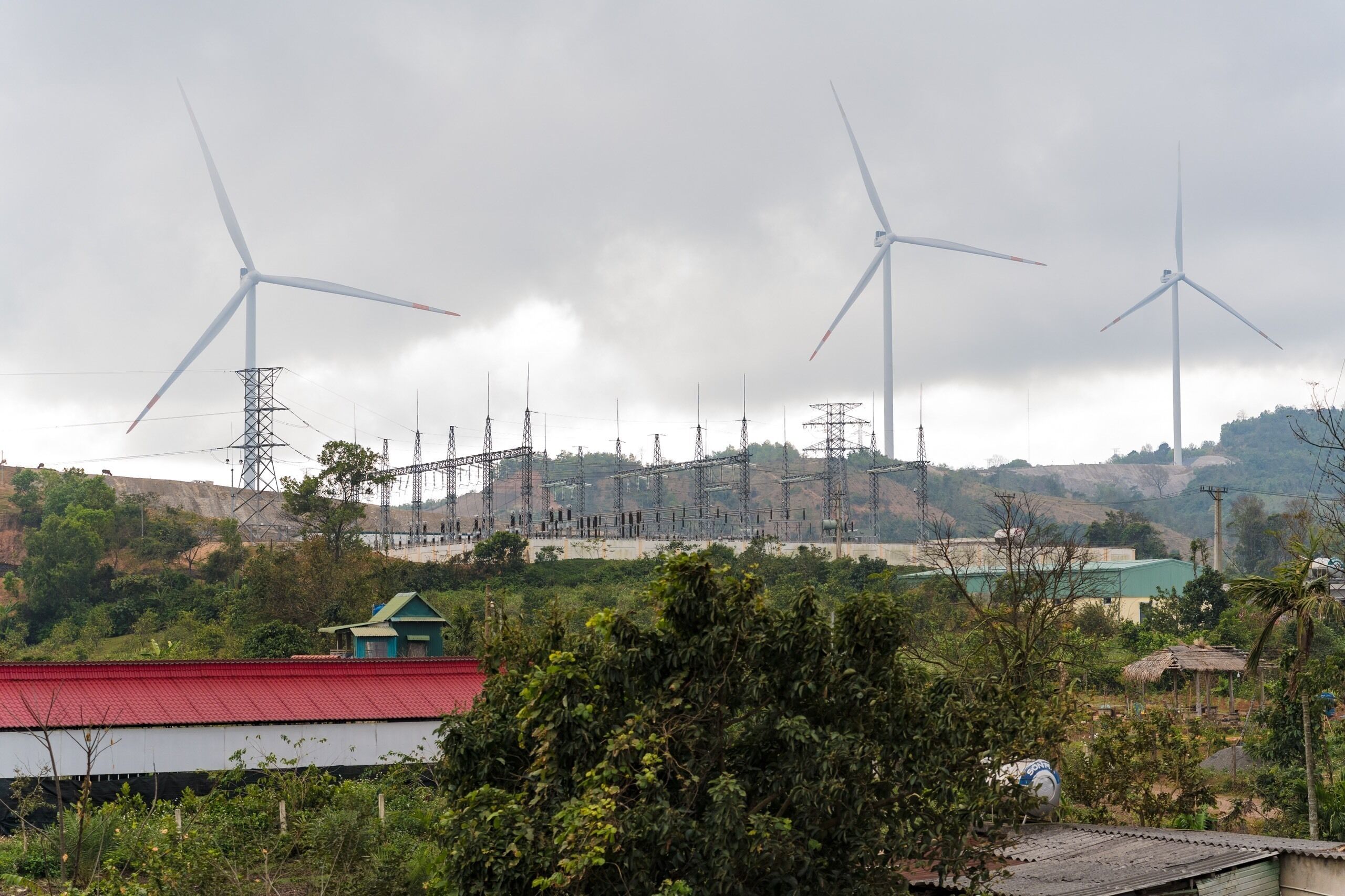 A wind farm with multiple wind turbines and electrical towers.