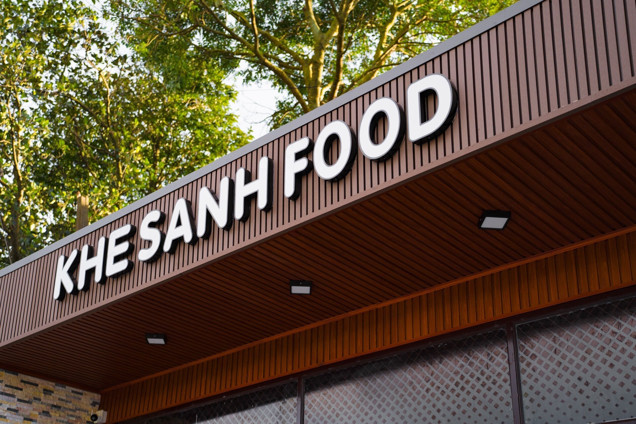 A sign with the text "KHESANH FOOD" on a building facade.