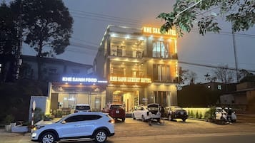 Um hotel com uma placa de destaque com a inscrição "KHE SANH LUXURY HOTEL" e uma entrada visível.