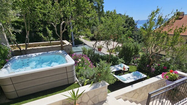 A rooftop garden with a hot tub, outdoor seating, and potted plants. - Holiday Home Sunrise (Omis)
