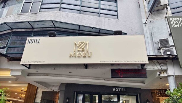 Een hotel ingang met een bord waarop 