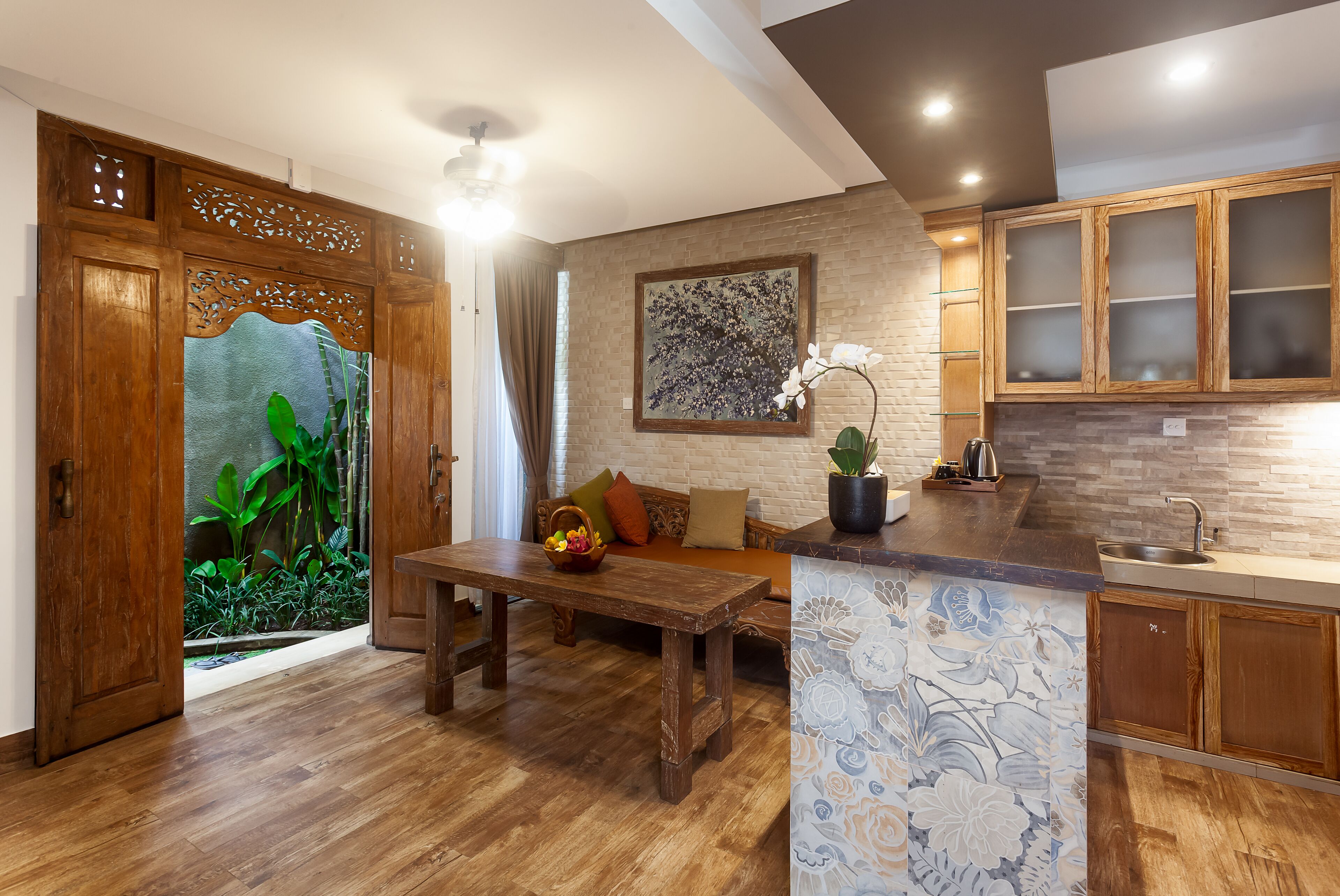 Una cocina moderna con armarios de madera, una isla integrada y una zona de comedor con una mesa y un banco de madera.