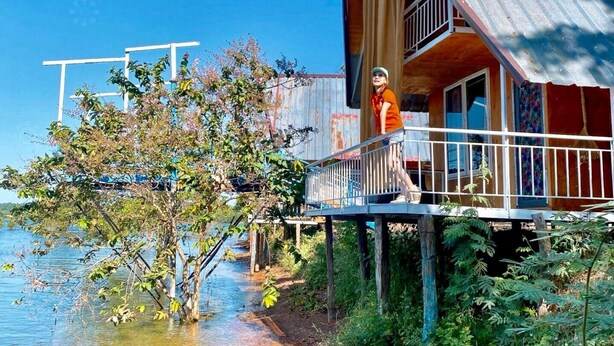 A wooden cabin with a balcony overlooking a body of water.
