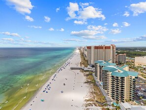 A beachfront hotel with multiple high-rise buildings, a sandy beach, and a clear view of the ocean. - Ground-Floor Beachfront Condo w/ Free Beach Chairs (Panama City Beach)