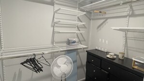 A walk-in closet with multiple shelves, a fan, and a black dresser. - Private Ensuite with Hot Spa at Upper Hutt, Wellington (Upper Hutt)