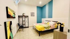 A bedroom with a bed, a chair, a desk, and artwork on the walls. - B&b Margherita Torremaggiore (Torremaggiore)