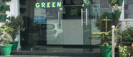 Un escaparate con un cartel que dice "GREEN PALMS".
