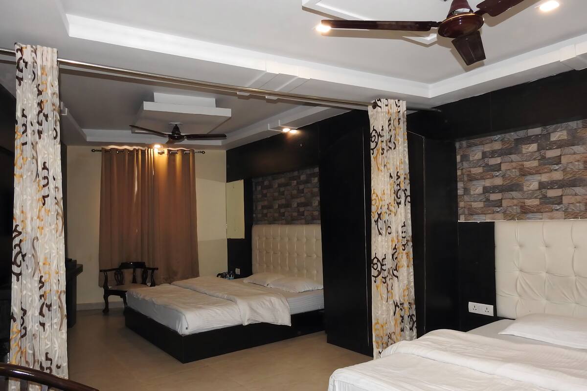 A hotel room with two beds, a ceiling fan, a brick accent wall, and a modern design.