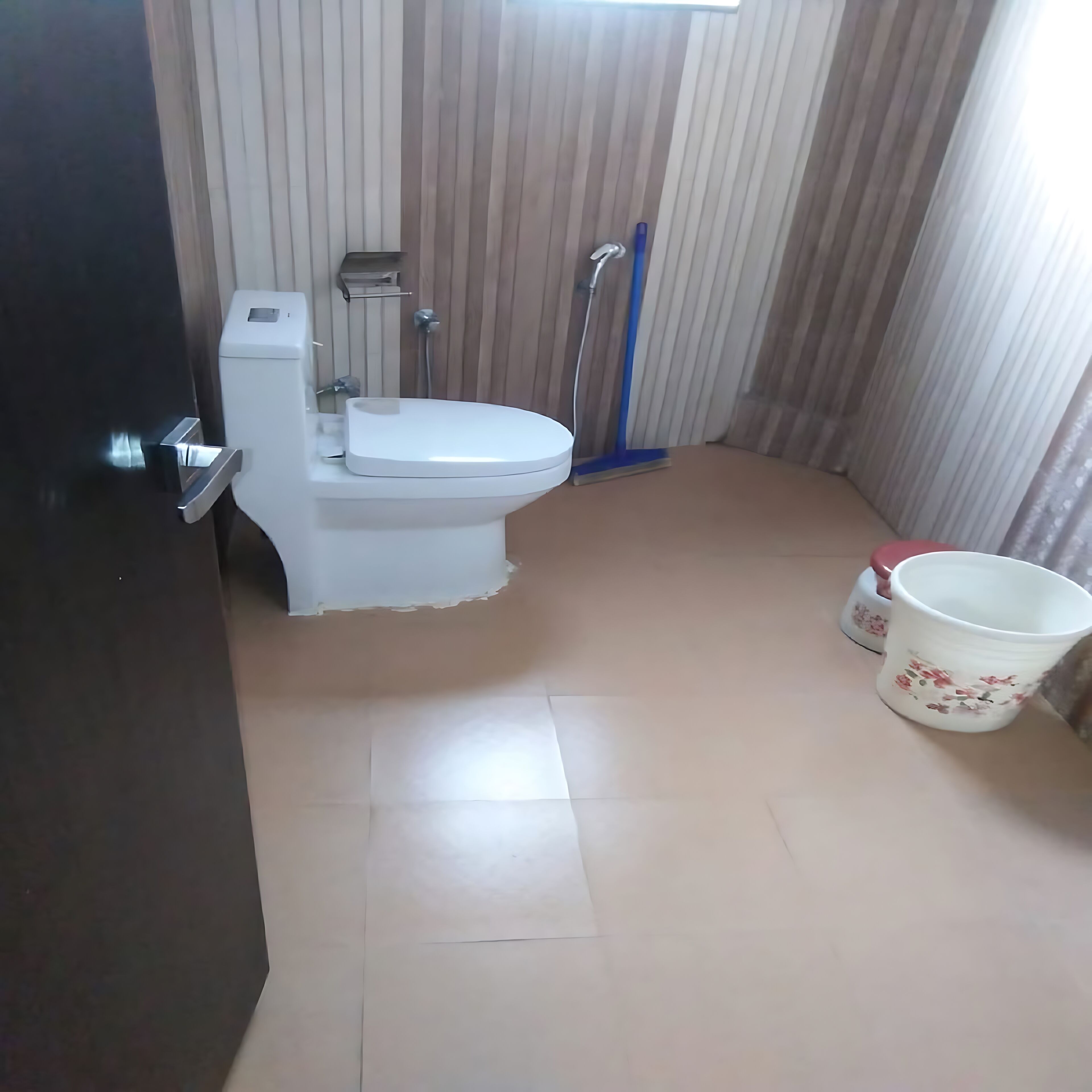 A small, clean bathroom with a toilet, a bidet, and a mop.