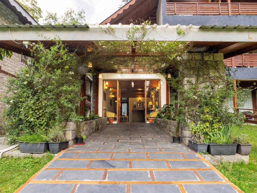 A stone pathway leading to a wooden entrance with a covered porch.