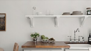 A kitchen with white cabinetry, a wooden countertop, and a stainless steel sink. - Charming Downtown Country Cottage (Chico)