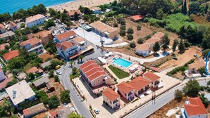 Vista aérea de una zona residencial con casas, una piscina y una playa.