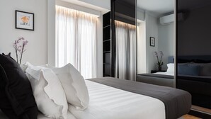 A modern bedroom with a large bed, a wardrobe, and a mirror.