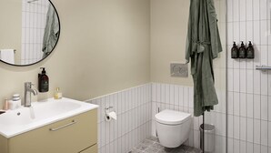 Une salle de bain équipée de toilettes, d’un lavabo, d’un miroir et d’une douche.