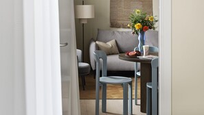 Une pièce confortable avec un lit, une table à manger et des chaises, un canapé et une lampe.