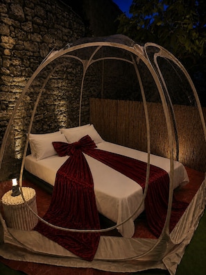 Un letto a baldacchino con un comodino.