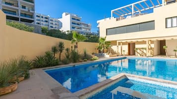 A swimming pool area with a modern building in the background.