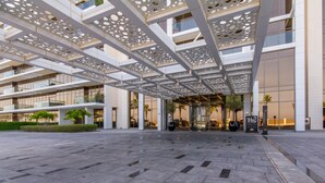 A modern hotel entrance with a geometric facade, large glass windows, and a patterned ceiling. - Bespoke Residences - Th8 Palm Jumeirah (Dubai)