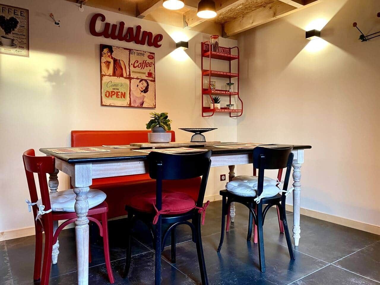 A restaurant interior with a red and black color scheme, a counter, and chairs.