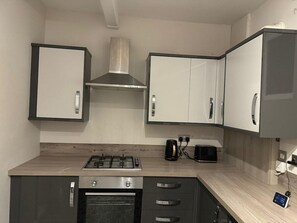 Una cocina moderna con estufa a gas, horno y microondas.