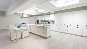 A modern kitchen with white cabinetry, a central island, and skylights. - The Great Beauty – Pantheon Luxury Stay (Roma)