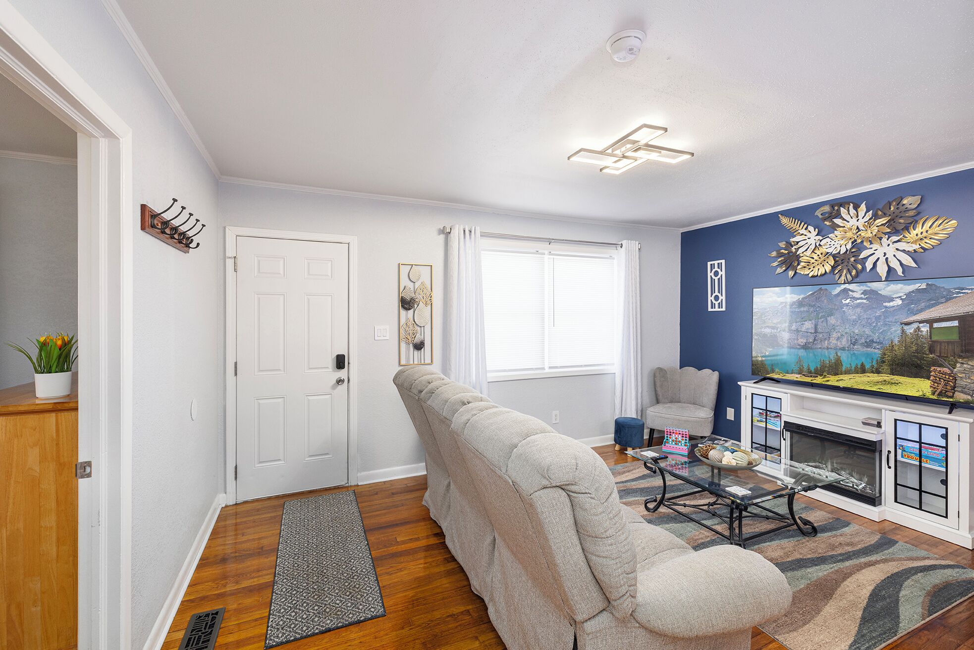A living room with a sofa, a coffee table, a fireplace, and a large TV.