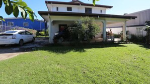 Een tweelaags huis met een overdekte veranda, een garage en een gazon.