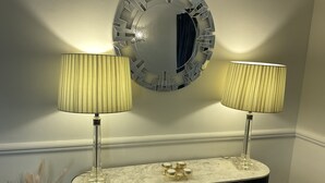 A bathroom vanity with two lamps, a mirror, and a decorative item on the countertop. - Stunning 4-bed House in Rochester (Rochester)