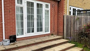A brick house with a white-framed window, a wooden fence, and a small garden area. - Stunning 4-bed House in Rochester (Rochester)
