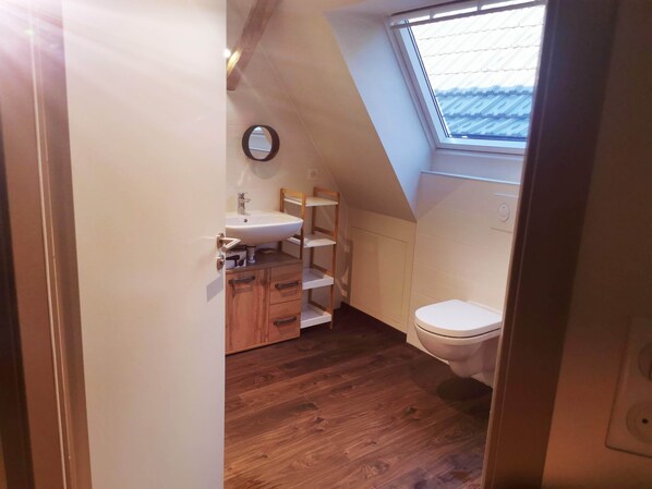 Chuveiro, secador de cabelo, toalhas de banho, papel higiênico